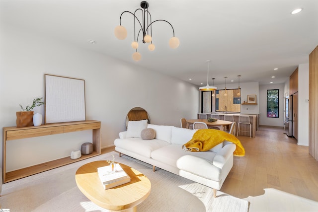 living room featuring light hardwood / wood-style flooring and an inviting chandelier