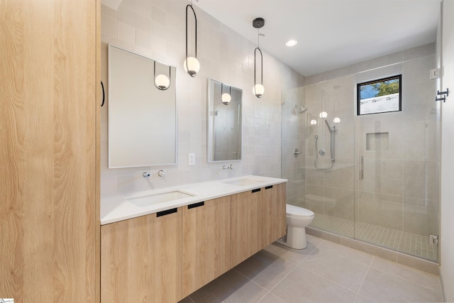 bathroom featuring tile patterned flooring, a shower with shower door, tile walls, and toilet