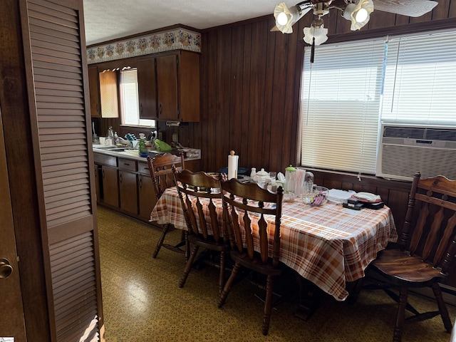 dining area with cooling unit and wooden walls