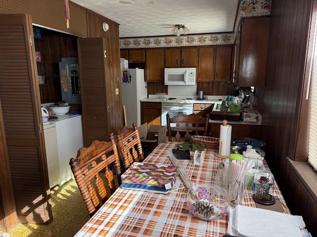 interior space featuring carpet, dark brown cabinetry, white appliances, and a textured ceiling