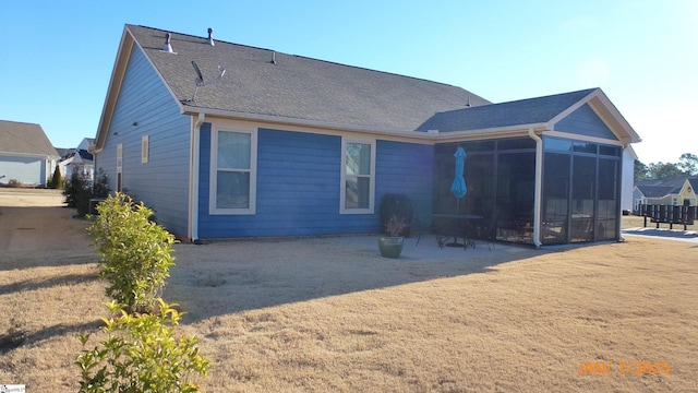 rear view of property featuring a sunroom