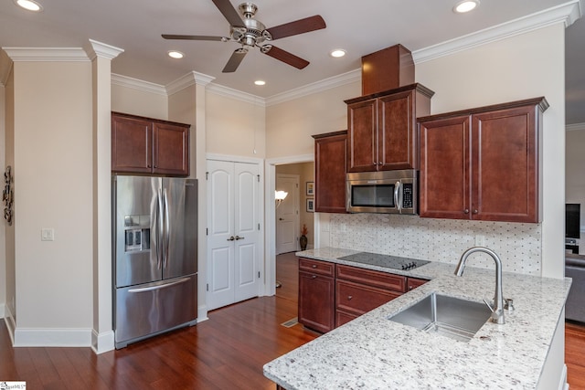 kitchen with decorative backsplash, light stone counters, ornamental molding, stainless steel appliances, and sink