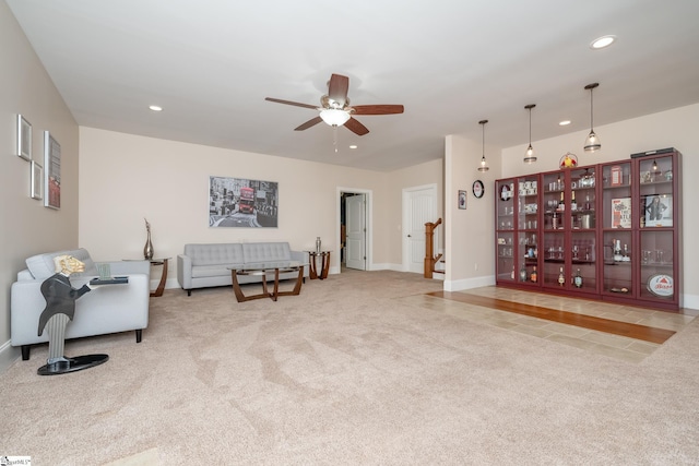 living area featuring light carpet and ceiling fan