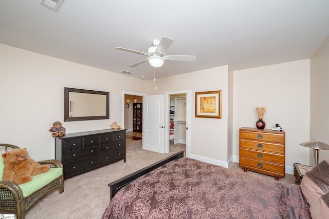 carpeted bedroom with a spacious closet, a closet, and ceiling fan