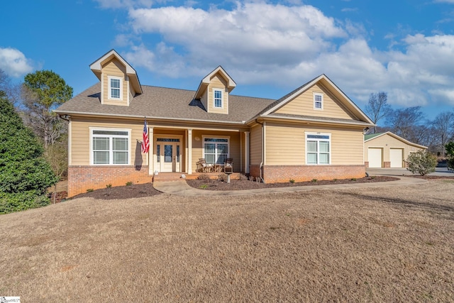 view of front of house featuring a porch, an outdoor structure, and a garage