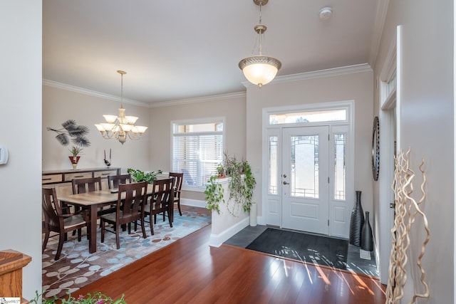 entryway featuring a notable chandelier, ornamental molding, and dark wood-type flooring