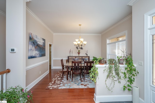 dining area featuring a chandelier, wood-type flooring, and ornamental molding