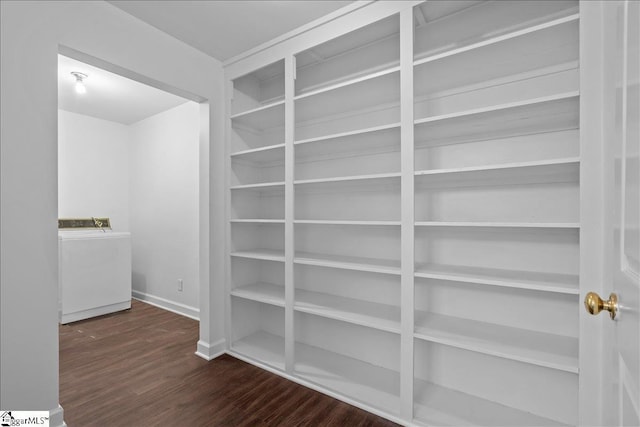 walk in closet featuring dark hardwood / wood-style flooring and washer / clothes dryer