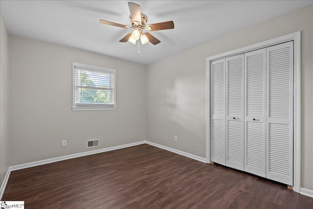 unfurnished bedroom featuring ceiling fan, dark wood-type flooring, and a closet