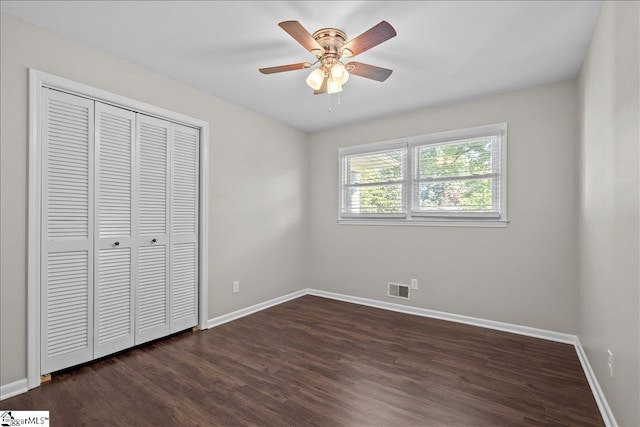 unfurnished bedroom featuring a closet, ceiling fan, and dark wood-type flooring