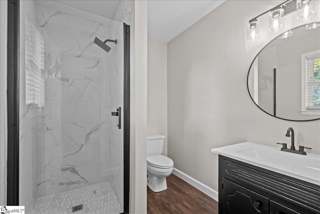 bathroom featuring toilet, vanity, an enclosed shower, and hardwood / wood-style flooring