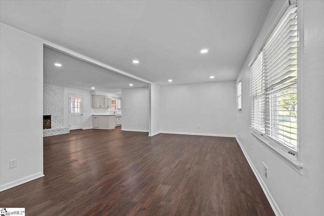 unfurnished living room featuring a fireplace and dark hardwood / wood-style floors