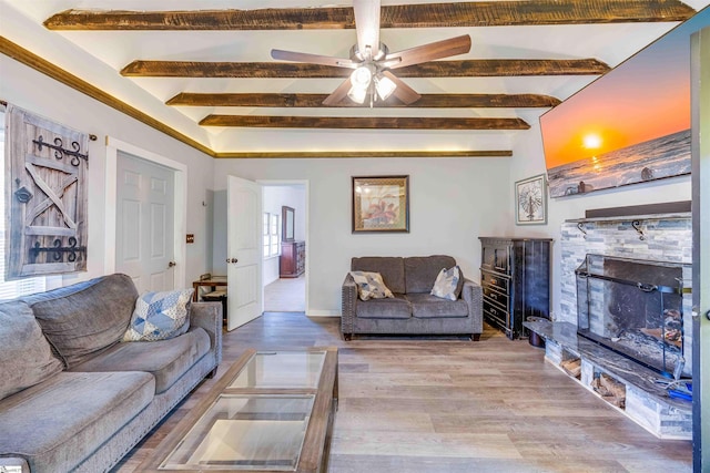 living room featuring beamed ceiling, ceiling fan, and light wood-type flooring