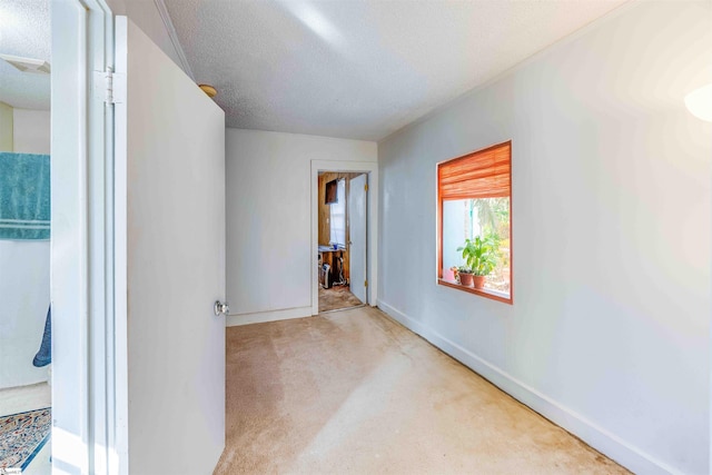 carpeted empty room featuring a textured ceiling