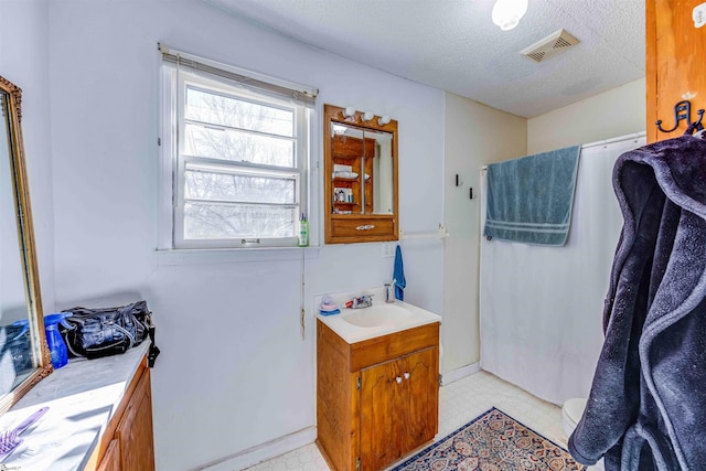 bathroom featuring a textured ceiling and vanity