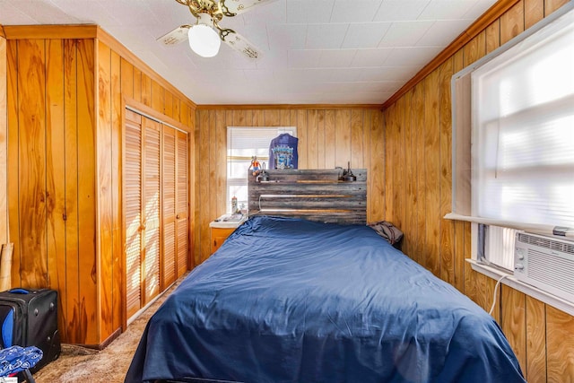 carpeted bedroom with ceiling fan, ornamental molding, and a closet