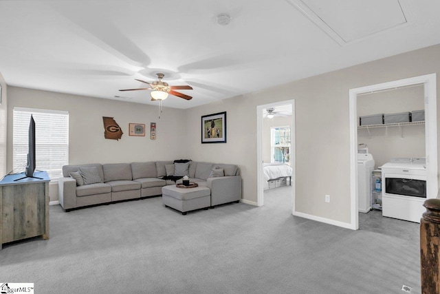 carpeted living room featuring washer / clothes dryer, ceiling fan, and a healthy amount of sunlight