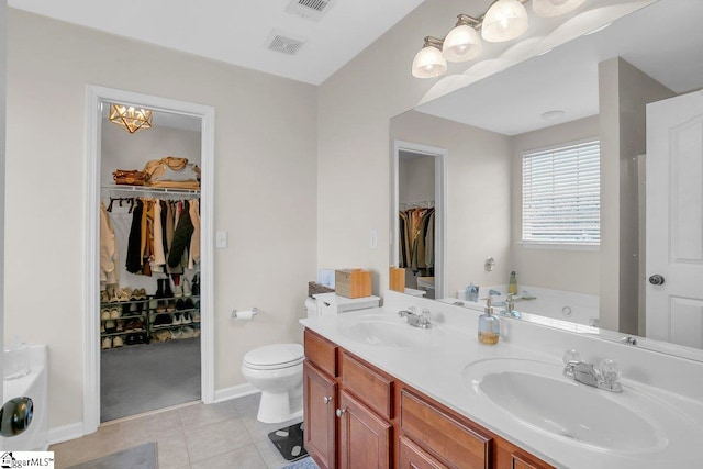 bathroom with vanity, an inviting chandelier, tile patterned flooring, a washtub, and toilet