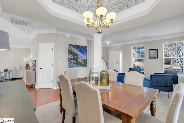 dining room with a tray ceiling, a notable chandelier, and ornamental molding