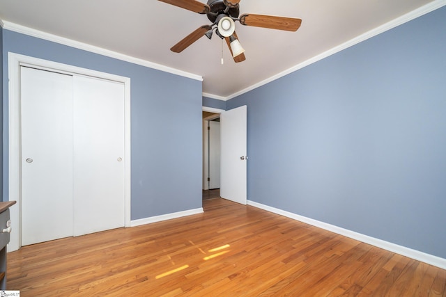 unfurnished bedroom with ceiling fan, light hardwood / wood-style floors, ornamental molding, and a closet