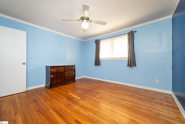 empty room featuring hardwood / wood-style flooring, ceiling fan, and crown molding