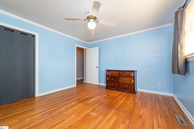 unfurnished bedroom with ceiling fan, crown molding, and light hardwood / wood-style flooring