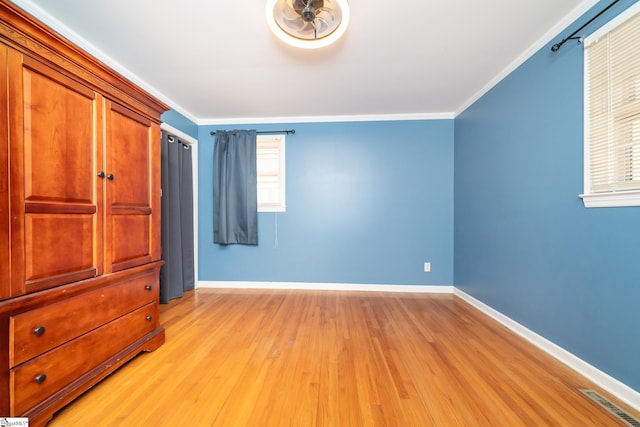 unfurnished bedroom with light wood-type flooring and ornamental molding