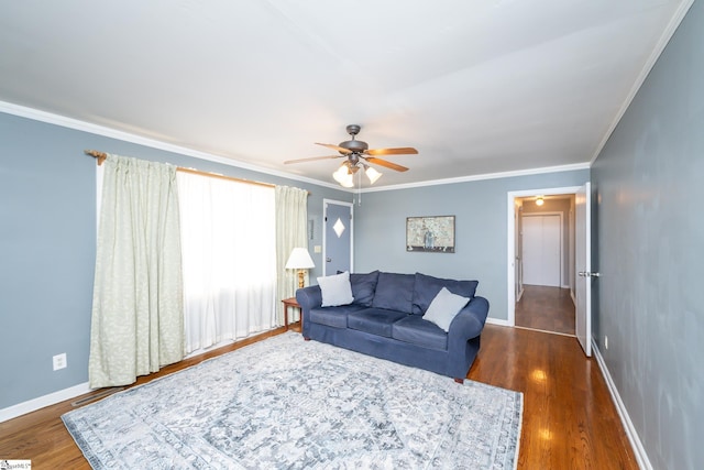 living room featuring dark hardwood / wood-style flooring, ceiling fan, and crown molding