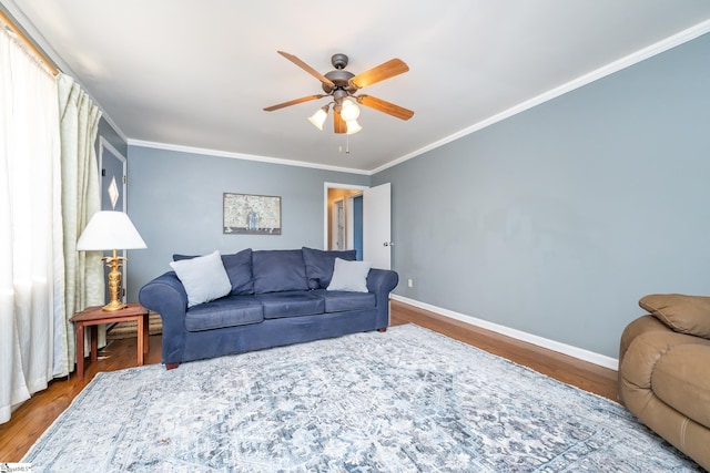 living room featuring hardwood / wood-style flooring, ceiling fan, and crown molding