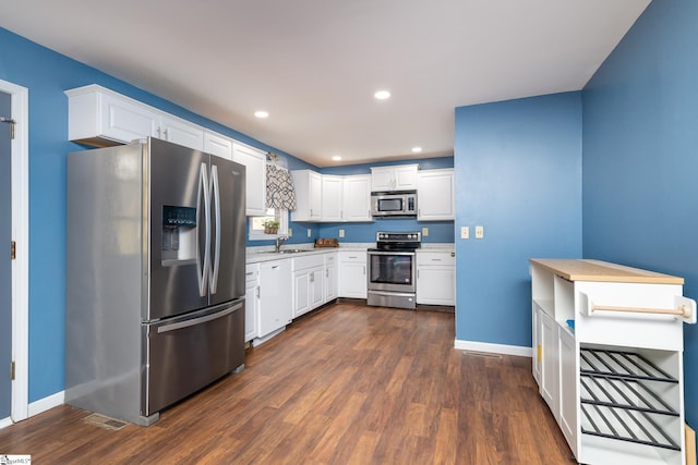 kitchen with white cabinets, dark hardwood / wood-style flooring, stainless steel appliances, and sink