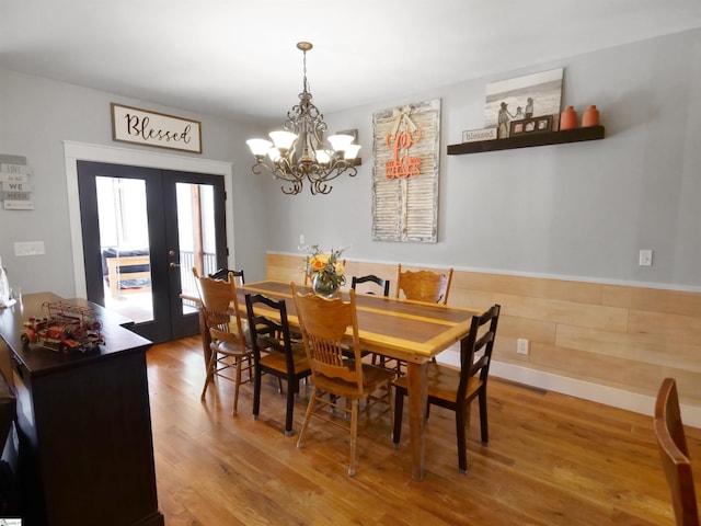 dining area featuring french doors, a notable chandelier, and hardwood / wood-style floors