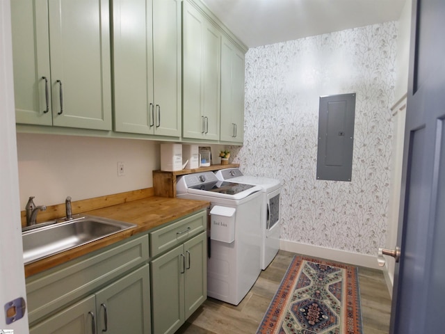 laundry room with sink, cabinets, independent washer and dryer, electric panel, and light hardwood / wood-style floors