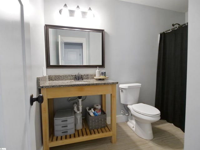 bathroom with a shower with shower curtain, toilet, and sink