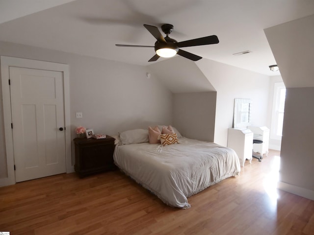 bedroom with ceiling fan, lofted ceiling, and light hardwood / wood-style flooring