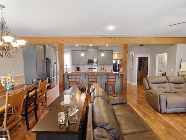 living room featuring light wood-type flooring and an inviting chandelier