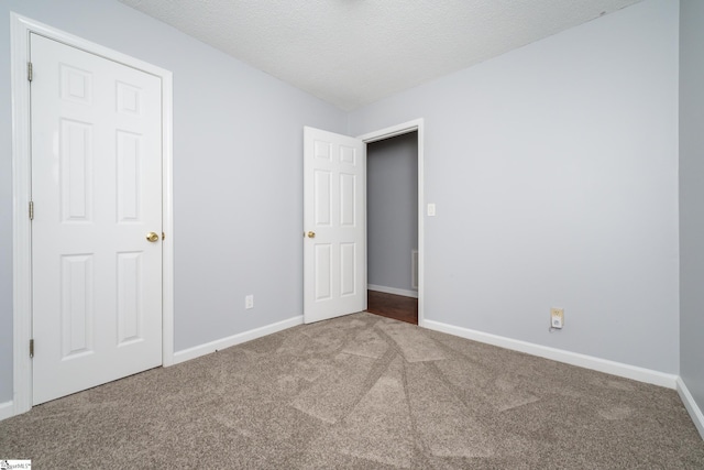 carpeted empty room featuring a textured ceiling