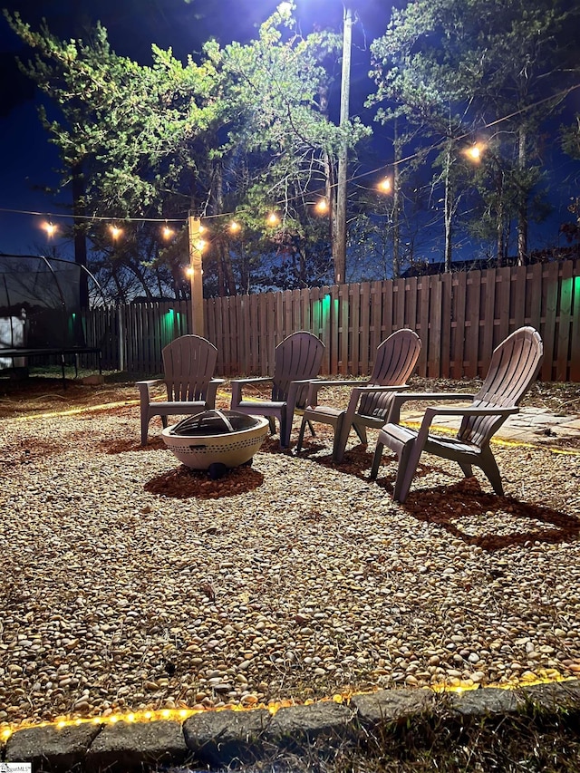 view of yard featuring a fire pit and a trampoline