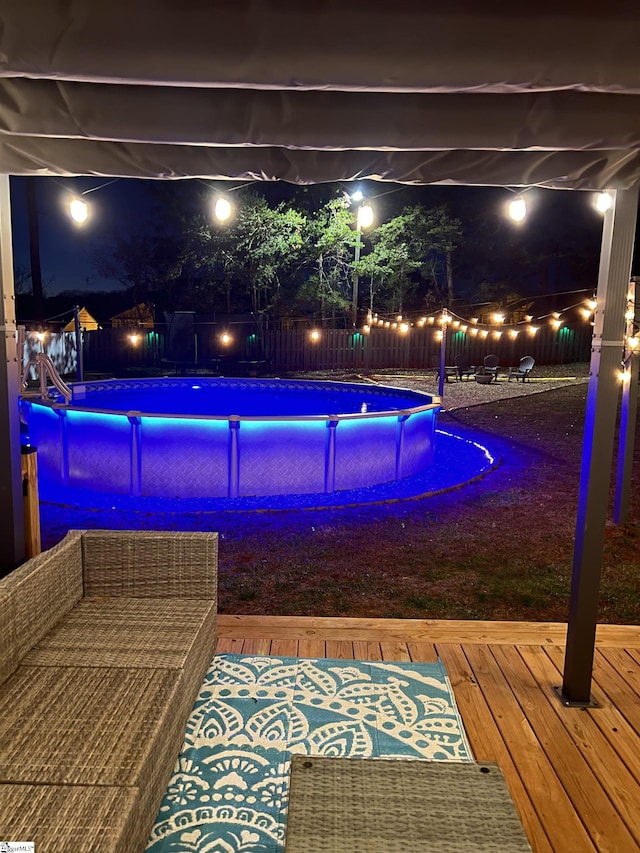 pool at twilight featuring a deck