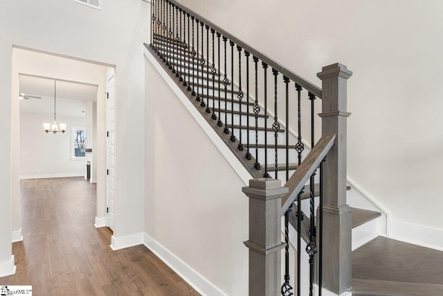 stairway featuring a chandelier and hardwood / wood-style flooring