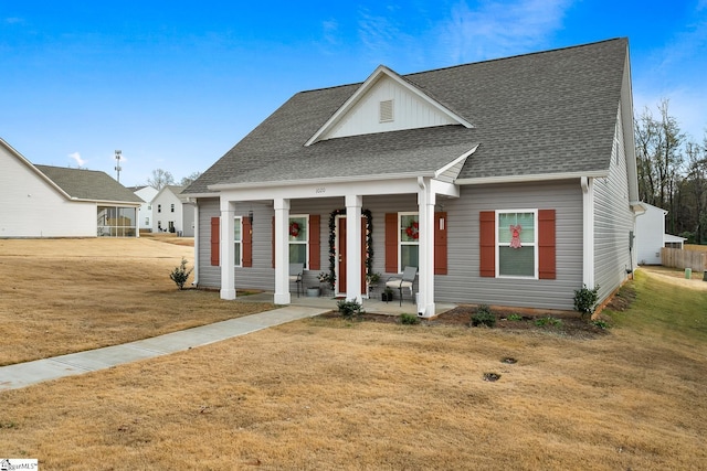 view of front facade featuring covered porch and a front yard