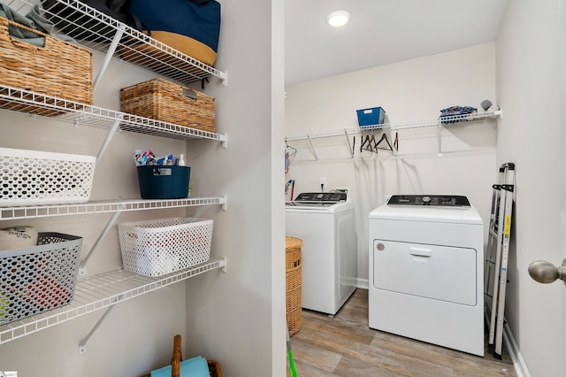 laundry area featuring washer and dryer and light hardwood / wood-style flooring