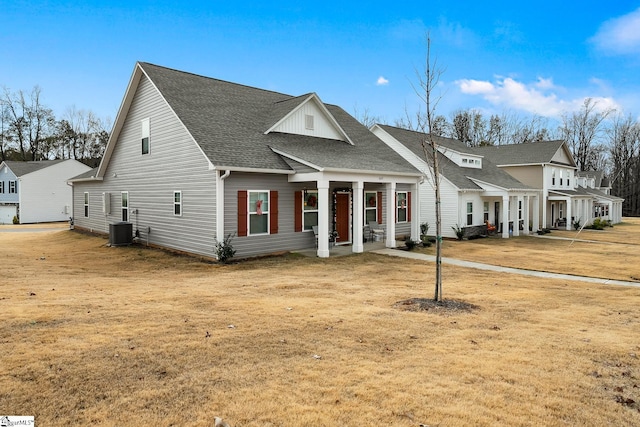 view of front of home with central air condition unit and a front lawn