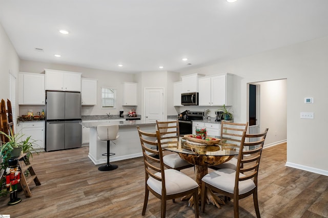 dining room with sink and wood-type flooring