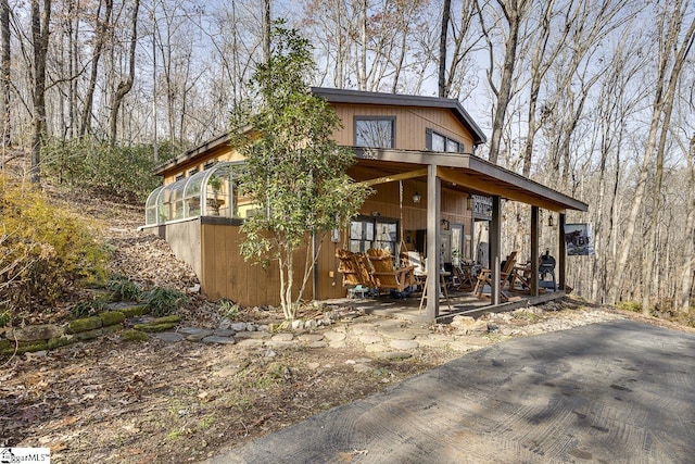 view of front of home featuring a sunroom and a patio area