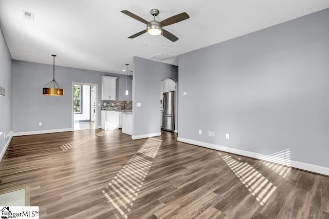 unfurnished living room featuring ceiling fan and dark hardwood / wood-style flooring