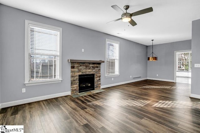 unfurnished living room featuring a fireplace, ceiling fan, and a healthy amount of sunlight