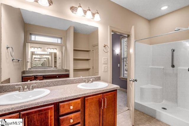 bathroom featuring walk in shower, tile patterned flooring, and vanity