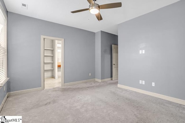 empty room with ceiling fan and light colored carpet