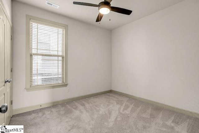 unfurnished room with light colored carpet and ceiling fan