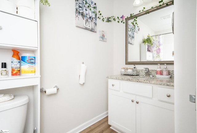 bathroom featuring hardwood / wood-style flooring, vanity, and toilet